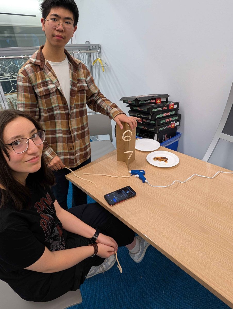 Two students building a cardboard tower at our engineering competition