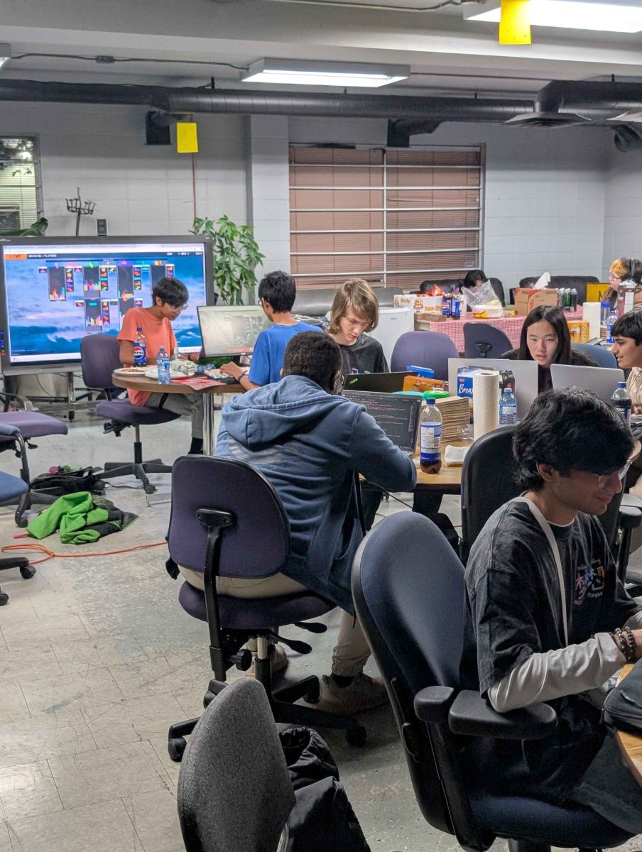 Participants at laptops with a multiplayer Tetris game on the big screen