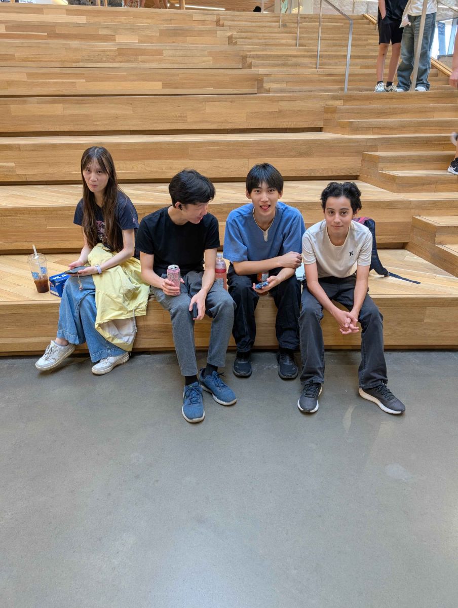 Four GFA team members sitting on the wooden steps at the library