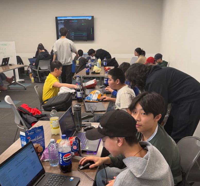Students coding at long tables during the WebDev Hackathon